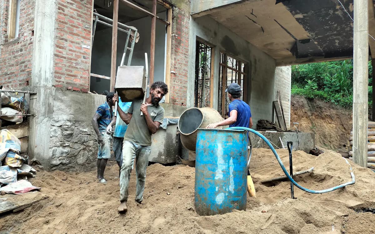 Workers carrying materials at a residential house construction site